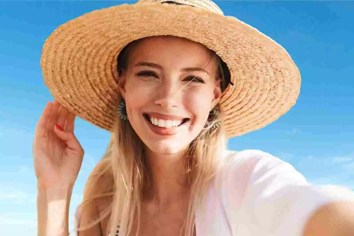 Mujer sonriente, con un sombrero de paja en la cabeza Mujer sonriente, con un sombrero de paja en la cabeza