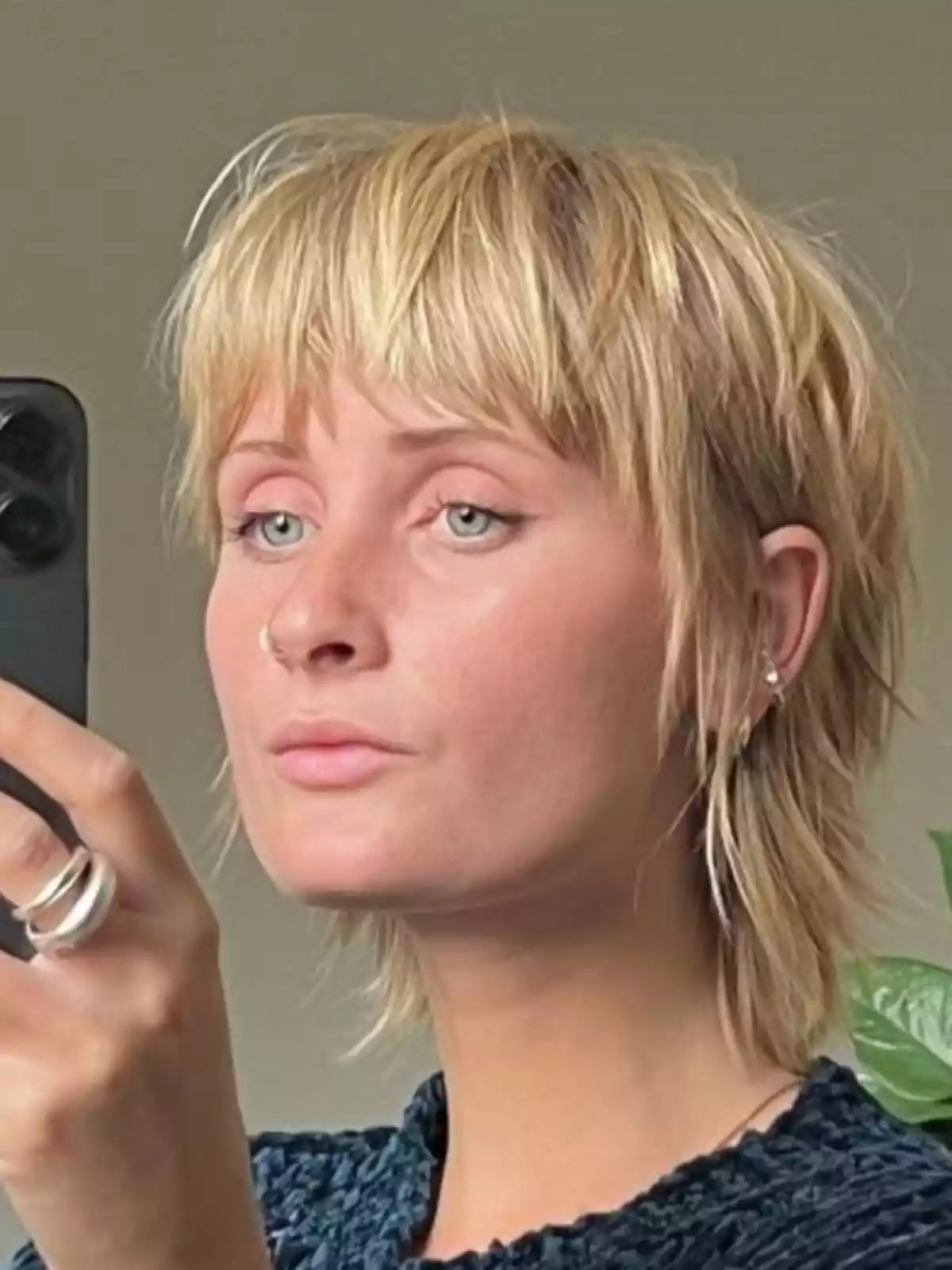 Mujer con corte de pelo mixie rubia haciéndose selfie Mujer con corte de pelo mixie rubia haciéndose selfie