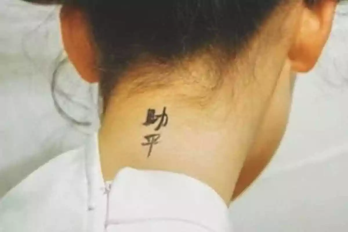 Foto detalle de una nuca femenina con un tatuaje de letras chinas Foto detalle de una nuca femenina con un tatuaje de letras chinas