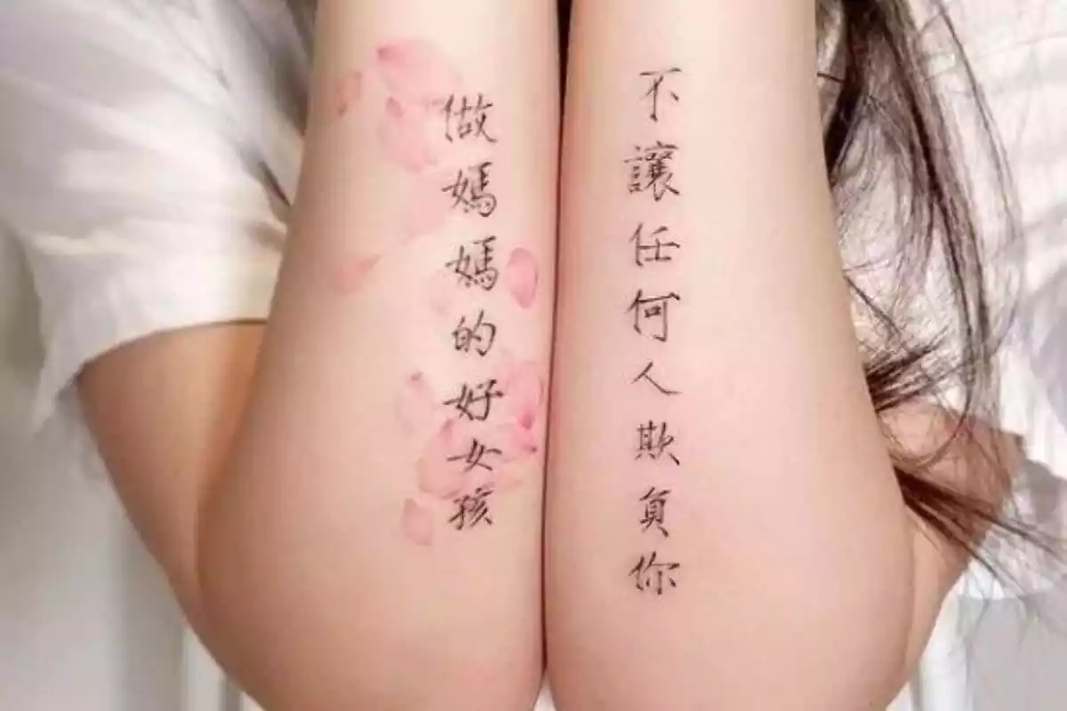 Foto detalle de dos brazos tatuados con letras chinas Foto detalle de dos brazos tatuados con letras chinas