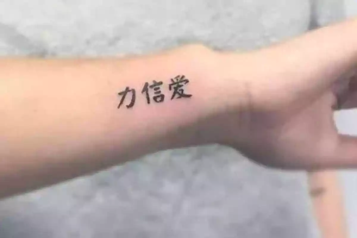 Foto detalle de un brazo que muestra un tatuaje con letras chinas Foto detalle de un brazo que muestra un tatuaje con letras chinas