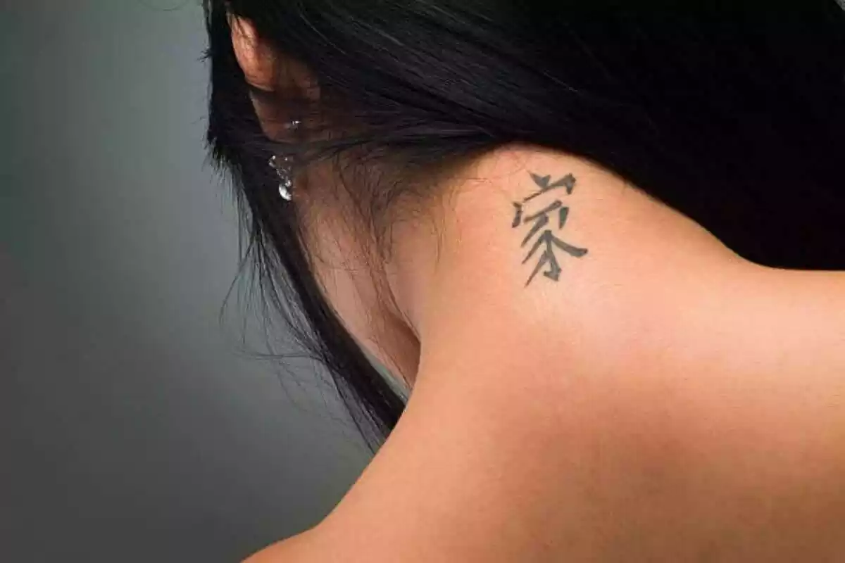 Foto detalle de una espalda y nuca femenina con un tatuaje de letra china Foto detalle de una espalda y nuca femenina con un tatuaje de letra china