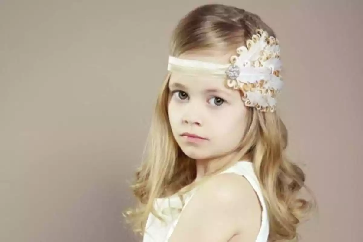 Niña rubia de comunión con ondas en el pelo, diadema y raya lateral Niña rubia de comunión con ondas en el pelo, diadema y raya lateral