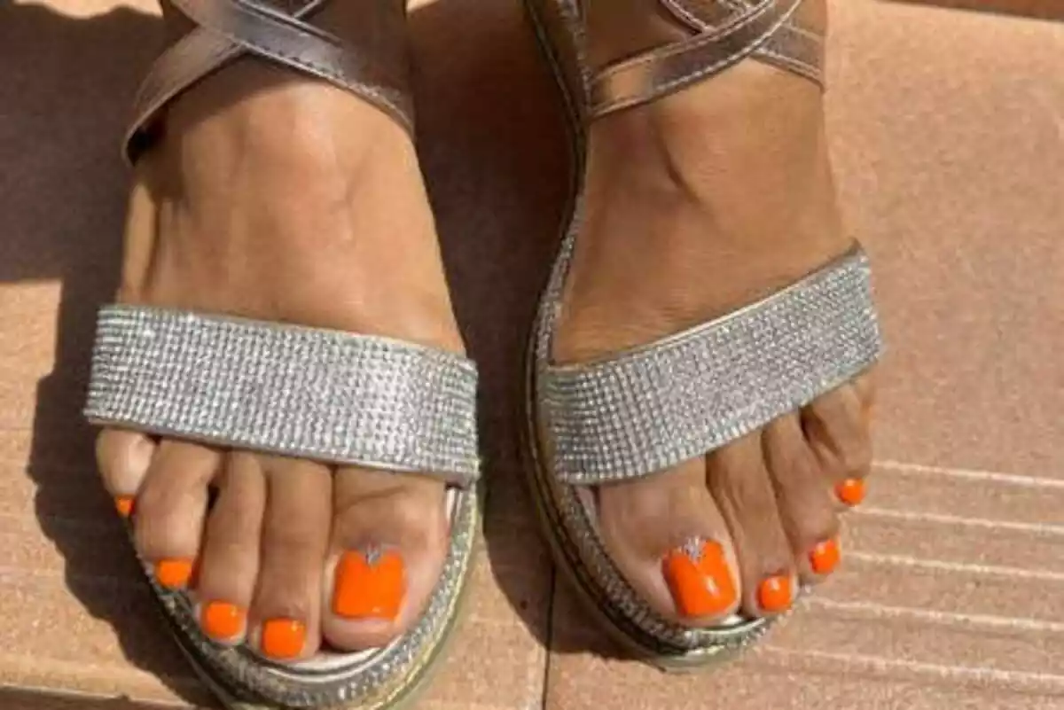 Fotografía de pies bonitos con sandalias y uñas color naranja Fotografía de pies bonitos con sandalias y uñas color naranja