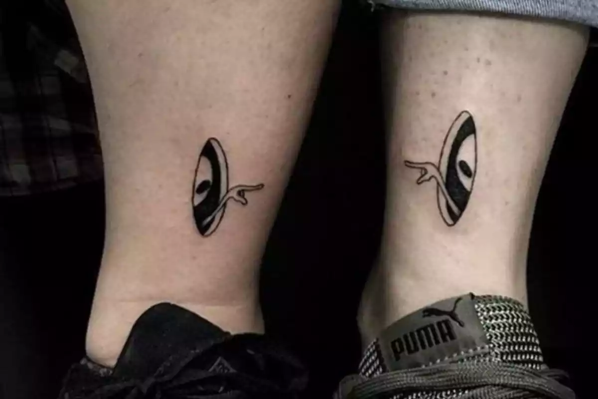 Cada tobillo tiene tatuados unos marcianos que se señalan con el dedo