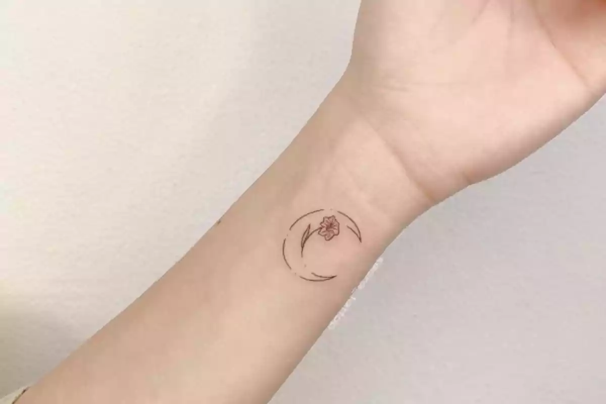 tatuaje en la muñeca de una flor en la luna