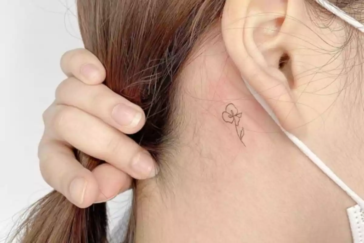 tatuaje de una flor detrás de la oreja