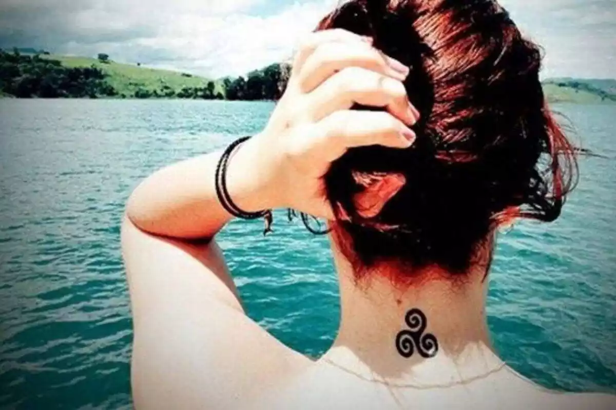Tatuaje triskel en el cuello de una joven mujer Tatuaje triskel en el cuello de una joven mujer
