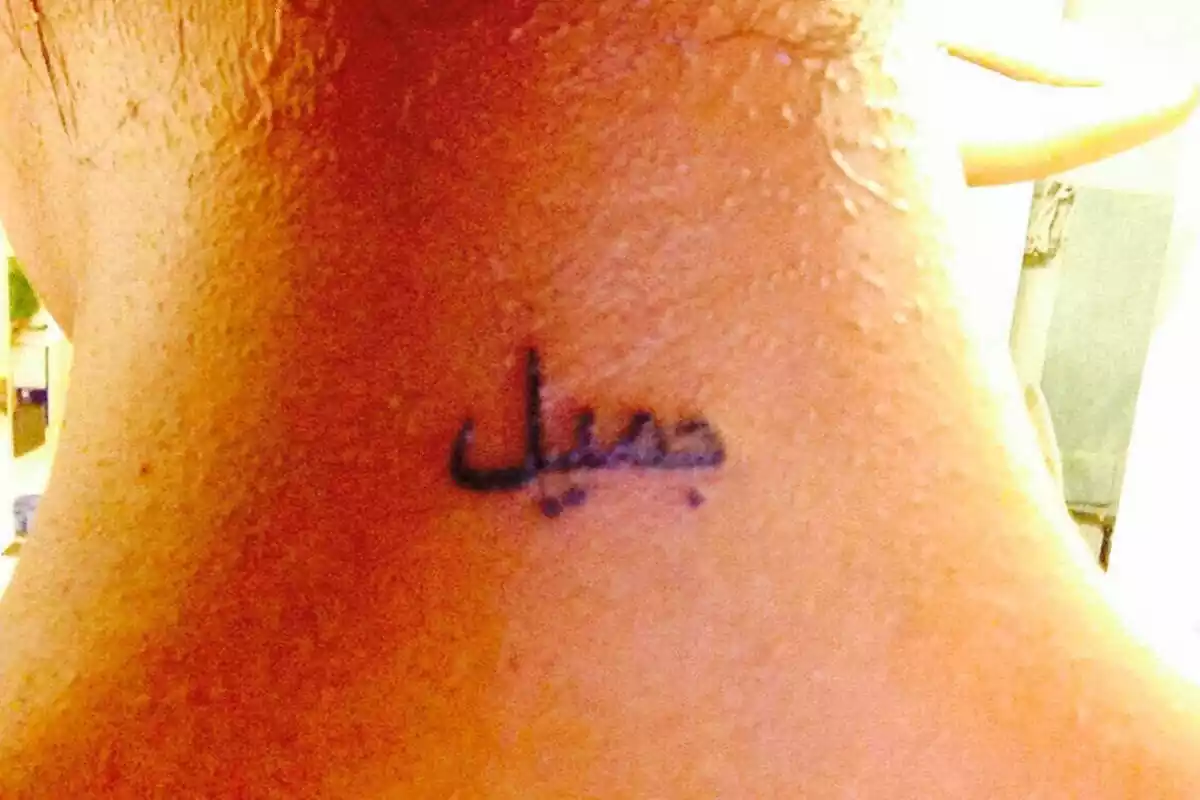 Foto detalle de cuello con un tatuaje con un diseño de letras árabes Foto detalle de cuello con un tatuaje con un diseño de letras árabes