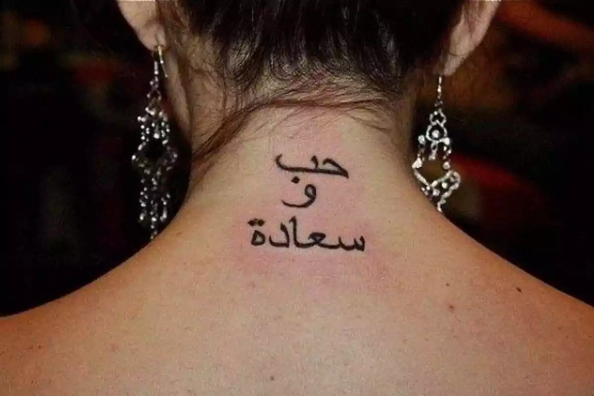 Foto espalda de mujer con diseño de tatuaje de letras árabes Foto espalda de mujer con diseño de tatuaje de letras árabes
