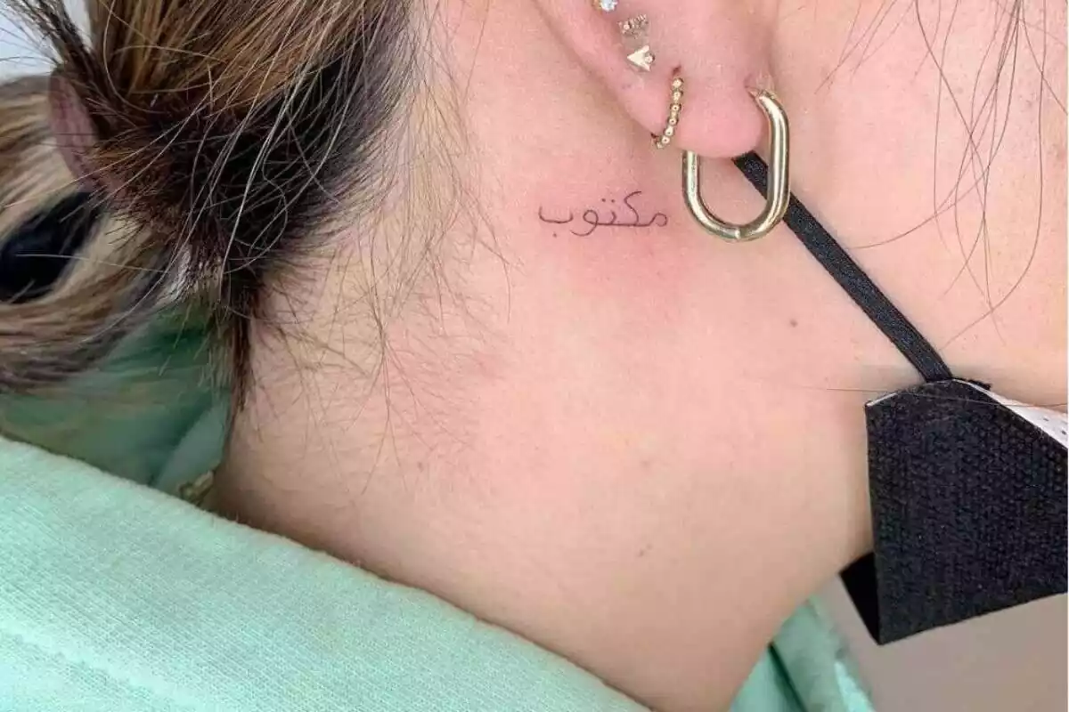 Foto detalle de una mujer con un tatuaje de letras árabes en el cuello Foto detalle de una mujer con un tatuaje de letras árabes en el cuello