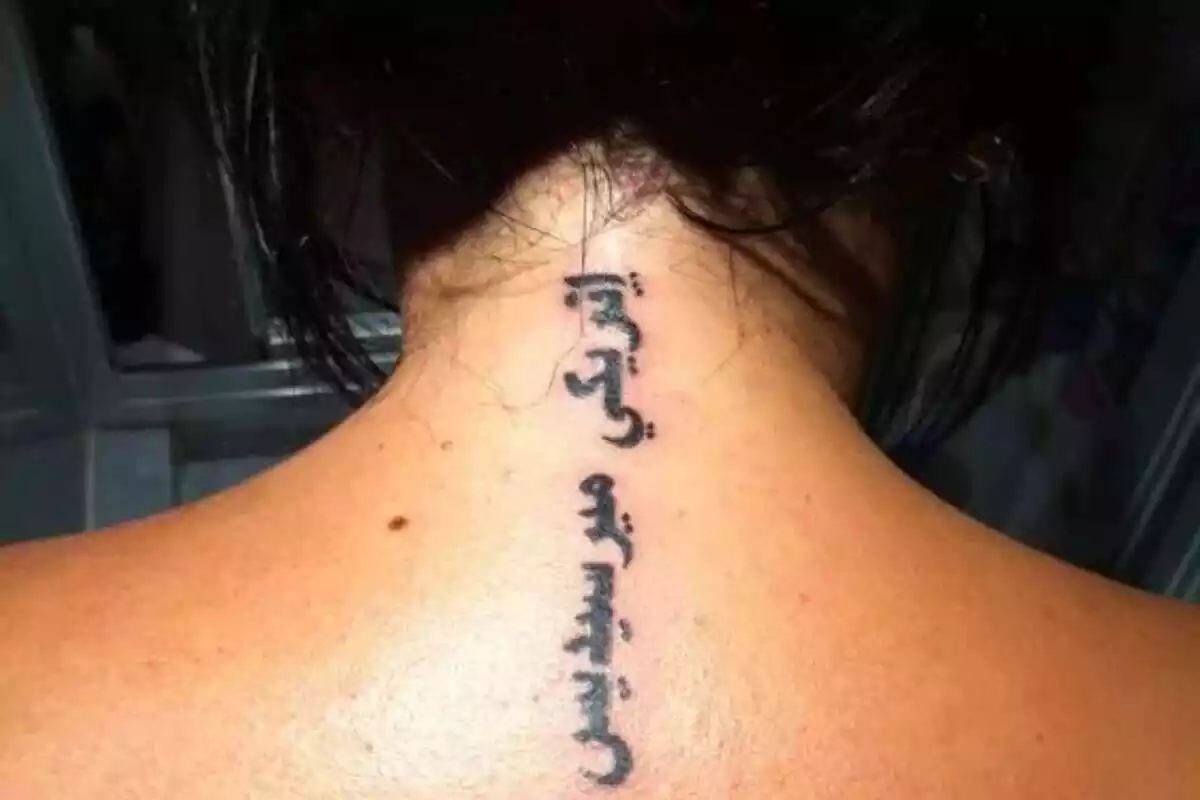 Letras arabes y cruz en la espalda