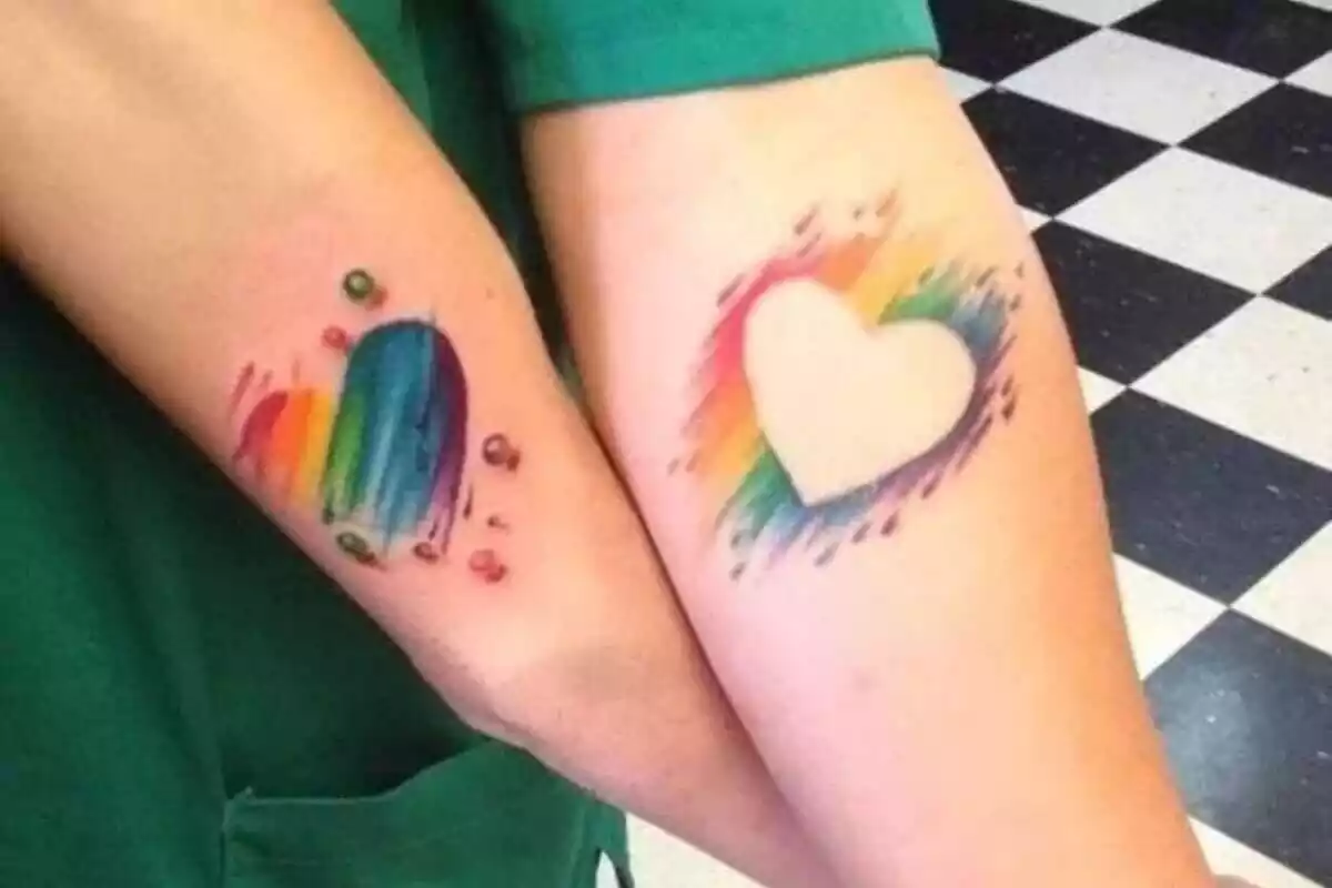 Foto detalle de unos brazos unidos por unos tatuajes de un corazón que parece pintado con pintura Foto detalle de unos brazos unidos por unos tatuajes de un corazón que parece pintado con pintura