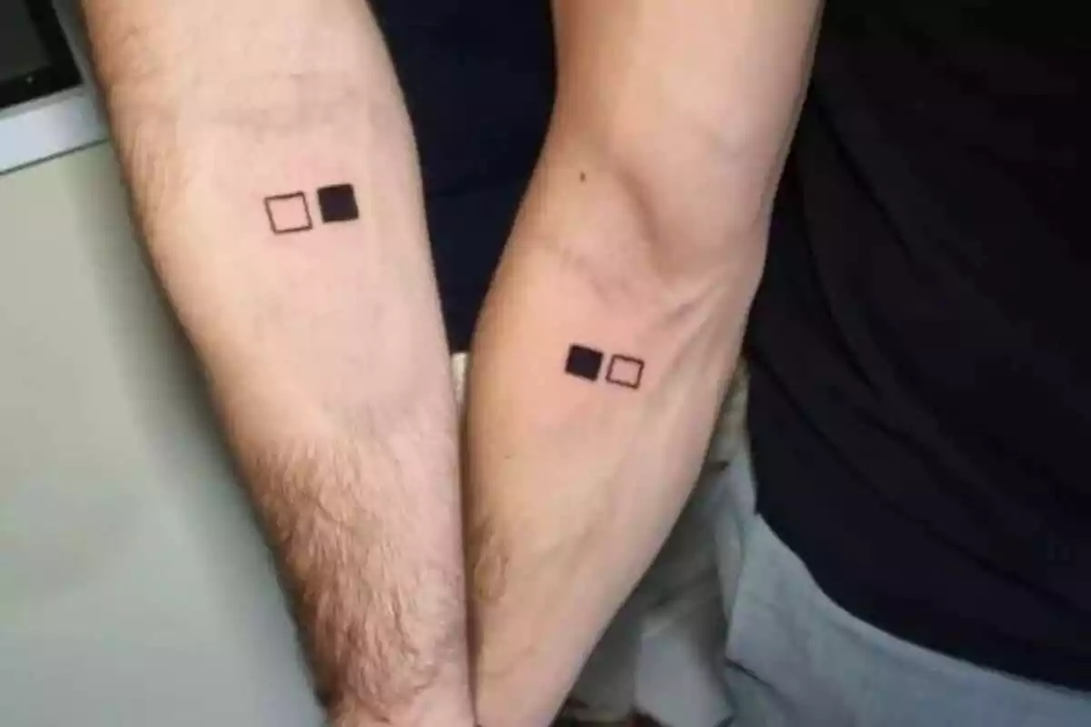 Foto detalle de unos brazos con tatuaje compartido de unos cuadrados en blanco y negro Foto detalle de unos brazos con tatuaje compartido de unos cuadrados en blanco y negro
