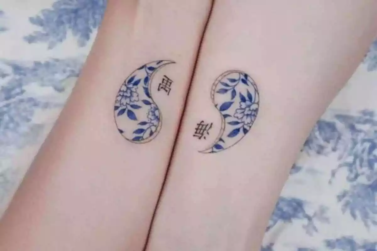 Foto detalle de una pareja de brazos compartiendo tatuaje espejo con símbolo del Ying y del Yang Foto detalle de una pareja de brazos compartiendo tatuaje espejo con símbolo del Ying y del Yang
