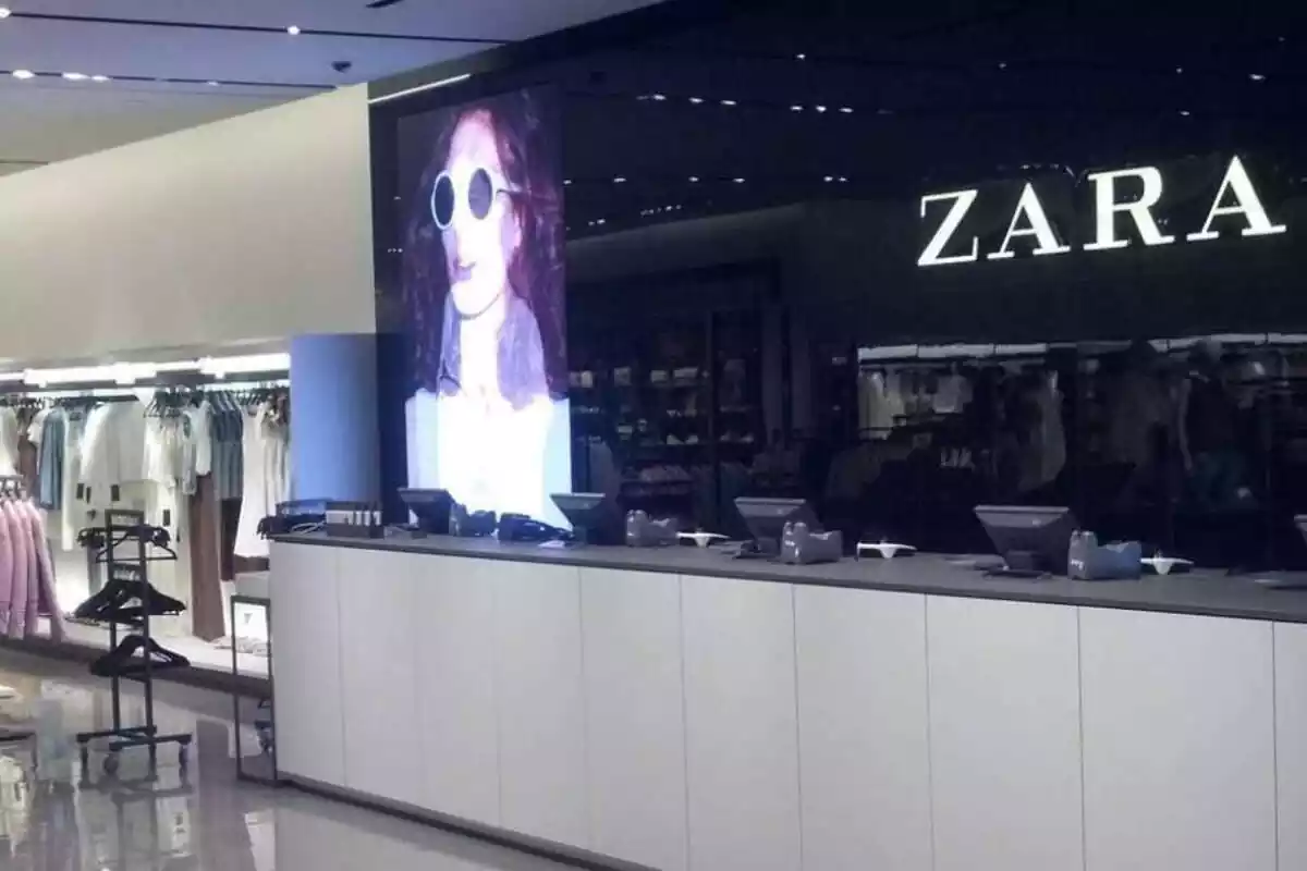 Interior de una tienda Zara. Cajas a la derecha con un cartel gigante de la tienda. Ropa a la derecha Interior de una tienda Zara. Cajas a la derecha con un cartel gigante de la tienda. Ropa a la derecha