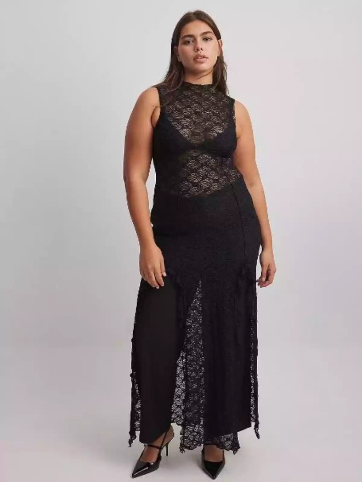 Mujer que luce un vestido largo con transparencias y un pantalón negro por debajo Mujer que luce un vestido largo con transparencias y un pantalón negro por debajo